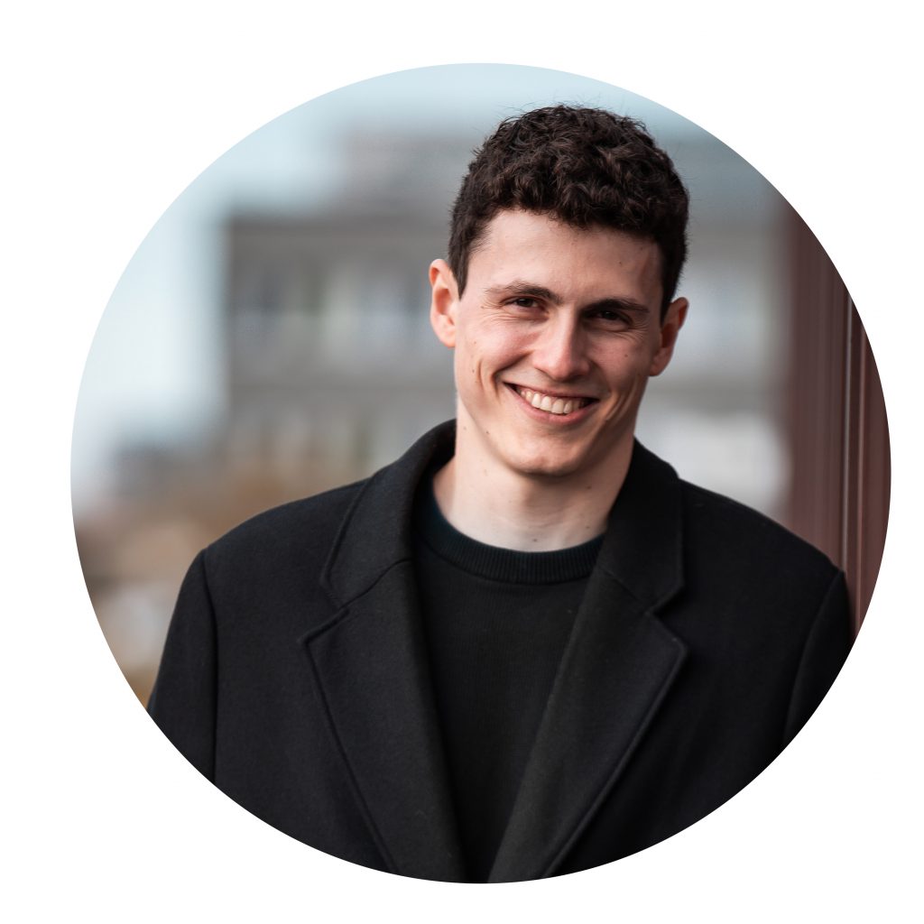 Portrait eines jungen Mannes im schwarzen Mantel vor unscharfem Hintergrund, kreisförmig freigestellt