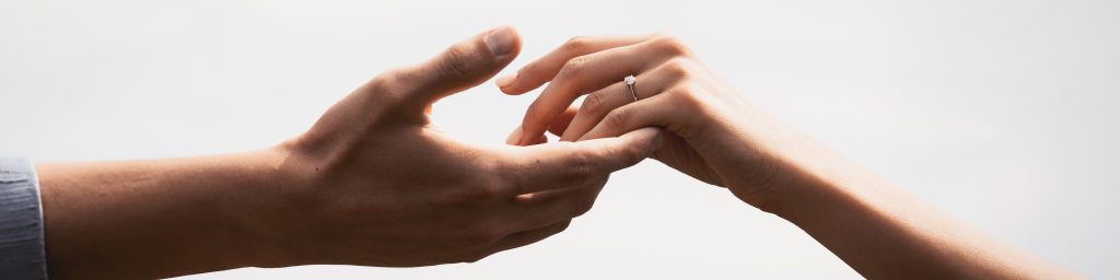 Detailaufnahme von Händen mit Eheringen – moderne, elegante Hochzeitsfotografie